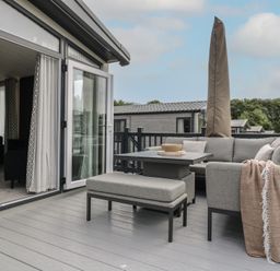 An outdoor seating area with a sofa and table at Lodge 8 St. Osyth