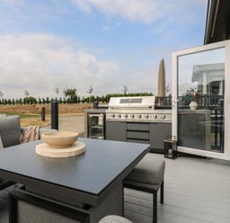 An outdoor patio with a grill and seating area at Lodge 8 St. Osyth