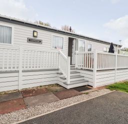 An outdoor view of a cabin with steps and a handrail at Clearwater in Morecambe