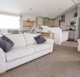 A living room with a sofa and dining area at Rosella 38 Morecambe