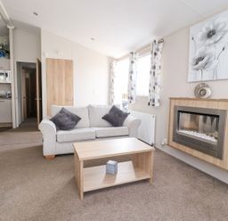 A living room with a sofa and coffee table at Rosella 38 in Morecambe