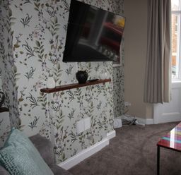 A living room with a television and decorative items at Brinkburn House in Scarborough