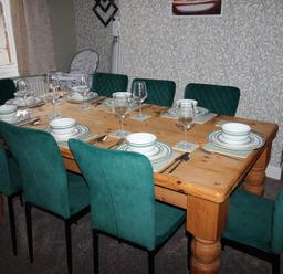 A dining room with a wooden table and green chairs at Brinkburn House in Scarborough