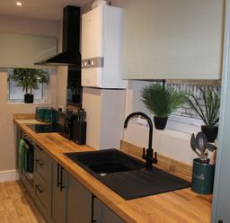 A kitchen with appliances and plants at Blackburn Heights Apartment 1 in Bridlington