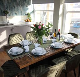 A dining room with a table set for a meal at Cornerhouse Apartment 1, Llandudno