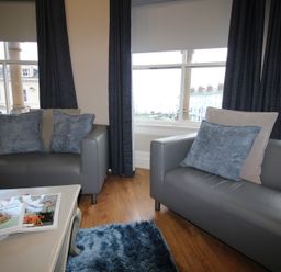 A living room with armchairs and a coffee table at Cornerhouse Apartment 2 in Llandudno