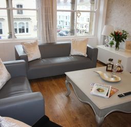 A living room with sofas, a coffee table, and a lamp at Cornerhouse Apartment 3 in Llandudno
