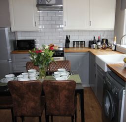A kitchen with a dining table set for four at Cornerhouse Apartment 4 in Llandudno