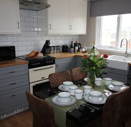 A kitchen with dining table and chairs at Cornerhouse Apartment 4 in Llandudno