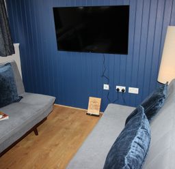 A living room with a television and two sofas at Cornerhouse Apartment 4 in Llandudno