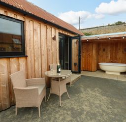 An outdoor area with a table and chairs and a bathtub at 2 West Dunkirk Neuk Hexham
