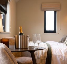 A bedroom with a champagne bucket and glasses at 2 West Dunkirk Neuk in Humshaugh