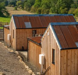 A view of wooden buildings with metal roofs in a rural setting at 2 West Dunkirk Neuk Humshaugh