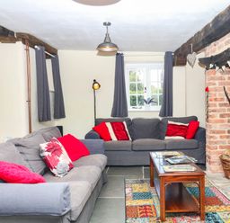 A living room with sofas and a table at The Cheese House near Charmouth