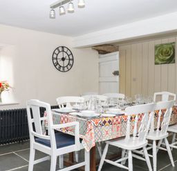 A dining room with a table set for a meal at The Cheese House near Charmouth