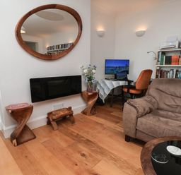 A living room with a television and a bookshelf at 26 Metropole Towers in Whitby