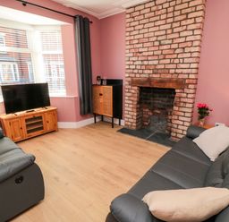 A living room with a television and a fireplace at Portobell House in Bridlington