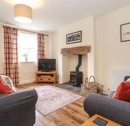 A living room with a television and fireplace at Irt Cottage in Seascale