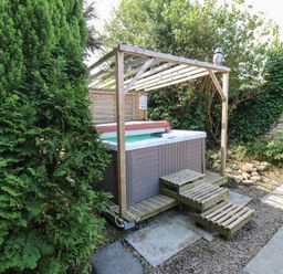 A hot tub on a wooden platform in a garden at Prudhoe Cottage in Prudhoe