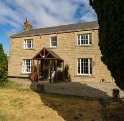 A house with a front porch and garden at Prudhoe Cottage in Prudhoe
