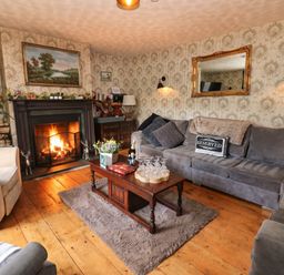 A living room with a fireplace and sofa at Prudhoe Cottage in Prudhoe