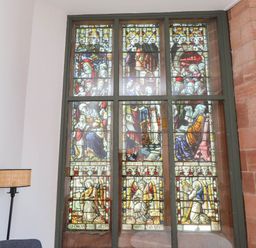 A stained glass window with various figures at Flat 16 in Criccieth