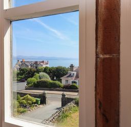 A view from a window showing houses and the ocean at Flat 16 Criccieth