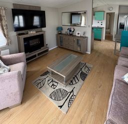 A living room with a television and coffee table at Lyons Robin Hood in Rhyl