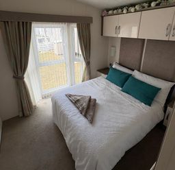 A bedroom with a bed and curtains at Lyons Robin Hood in Rhyl