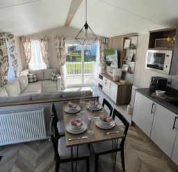 A living room with a sofa, table, and chairs at Unity Beach in Burnham-on-Sea