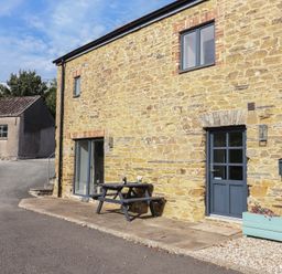 An outdoor seating area with a table and chairs at The Old Dairy near Liskeard