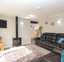 A living room with a television and sofa at The Old Dairy near Liskeard