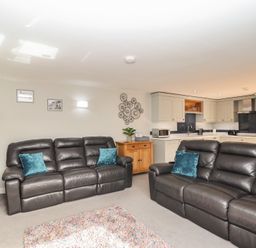 A living room with seating and kitchen area at The Old Dairy near Liskeard
