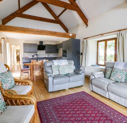 A living room with a dining table and sofas at May Cottage St Davids