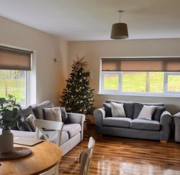 A living room with a Christmas tree and seating at Saddleback Bungalow Llandrindod Wells