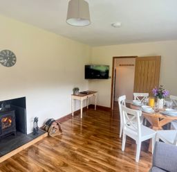 A dining room with a table and chairs at Saddleback Bungalow in Llandrindod Wells