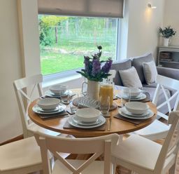 A dining table set with plates and glasses at Saddleback Bungalow in Llandrindod Wells