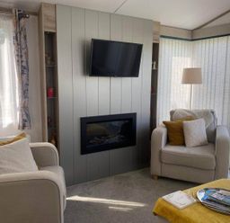 A living room with a TV and fireplace at Findhorn Lodge Peaceful Sleeps 4 in Forres