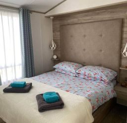 A bedroom with a bed and towels at Findhorn Lodge Peaceful Sleeps 4 in Forres