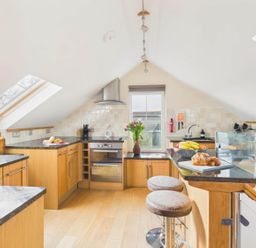 A kitchen with countertops and bar stools at Apartment Sleeps 4 Enclosed Garden Pets Welcome Flushing