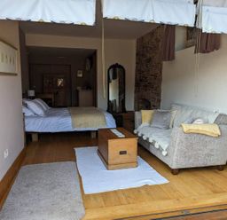 A living room with a bed and sofa at The Old Chapel of Ermington Converted Vestry in Ermington