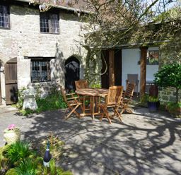 An outdoor area with a table and chairs near a stone wall at The Old Barn in Manchester