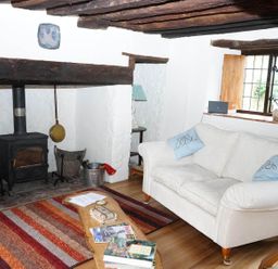 A living room with a couch and wood stove at The Old Barn in Manchester