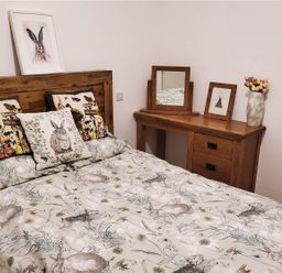 A bedroom with a bed and wooden furniture at 3 Bedroom Cottage Hot Tub Garden Parking Dunkeswell