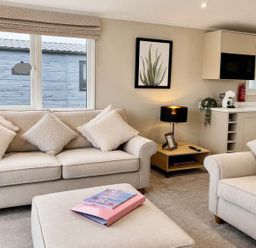 A living room with a sofa and a coffee table at Lovely Holiday Home On Waxham Sands in Great Yarmouth