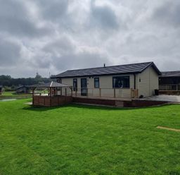 A lodge with a patio and grass area at Pet Friendly 2Bed Luxury Lodge in Routh HotTub Heron Lakes Luxury Lodge Park near Beverley