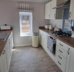 A kitchen with a sink, gas stove, and window at Pet Friendly 2Bed Luxury Lodge in Routh HotTub near Heron Lakes Luxury Lodge Park near Beverley