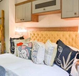 A bedroom with a bed and decorative cushions at Boutique lodge with hot tub sleeps 6 in Bridlington