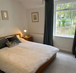 A bedroom with a bed and window at Charming 3Bed Cottage Private Garden Parking in Torquay