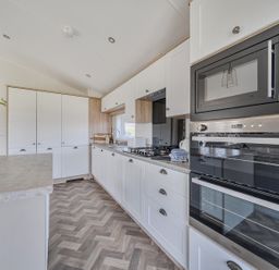 A kitchen with cabinets and appliances at Atlantic Breeze Luxury Lodge sleep 6 Mullacott near Ilfracombe